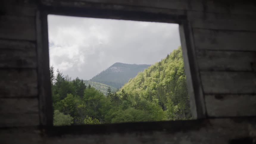 Through the window are hills filled with trees