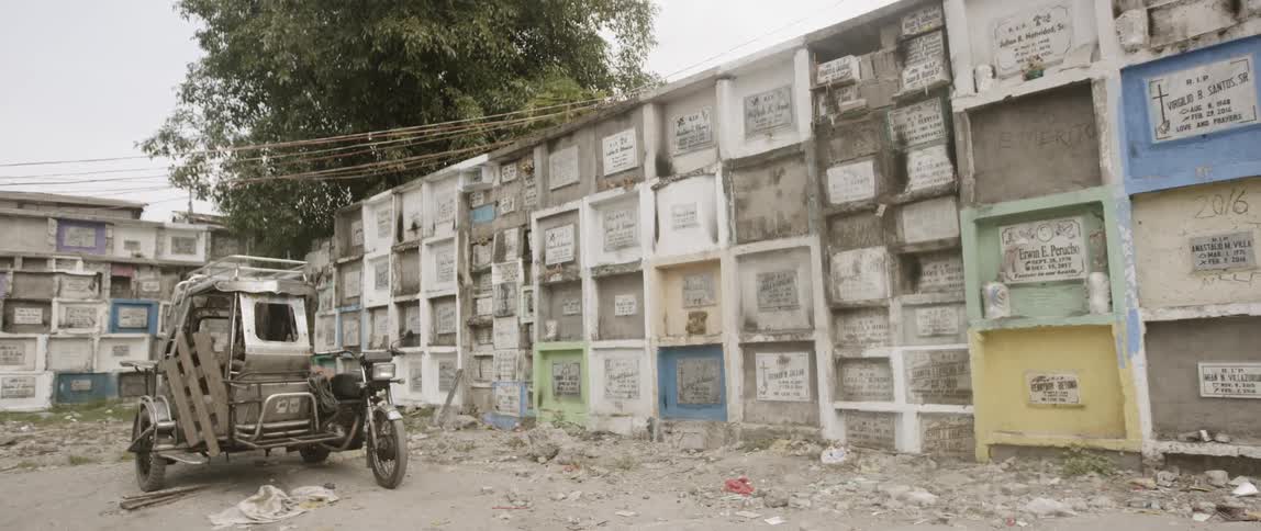 Motorcycle and metal trailer parked next to a wall of plaques