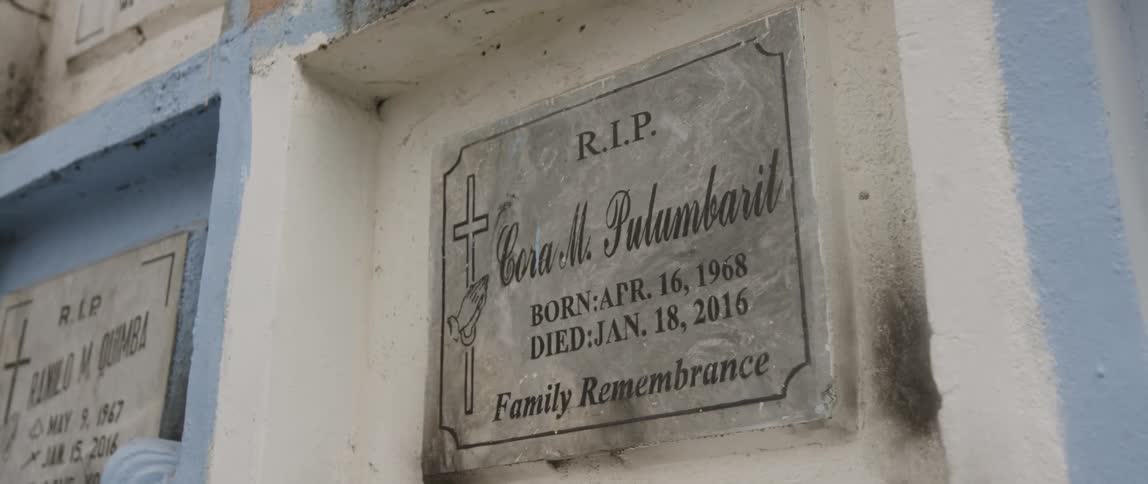 Camera shows memorial plaque on a white wall