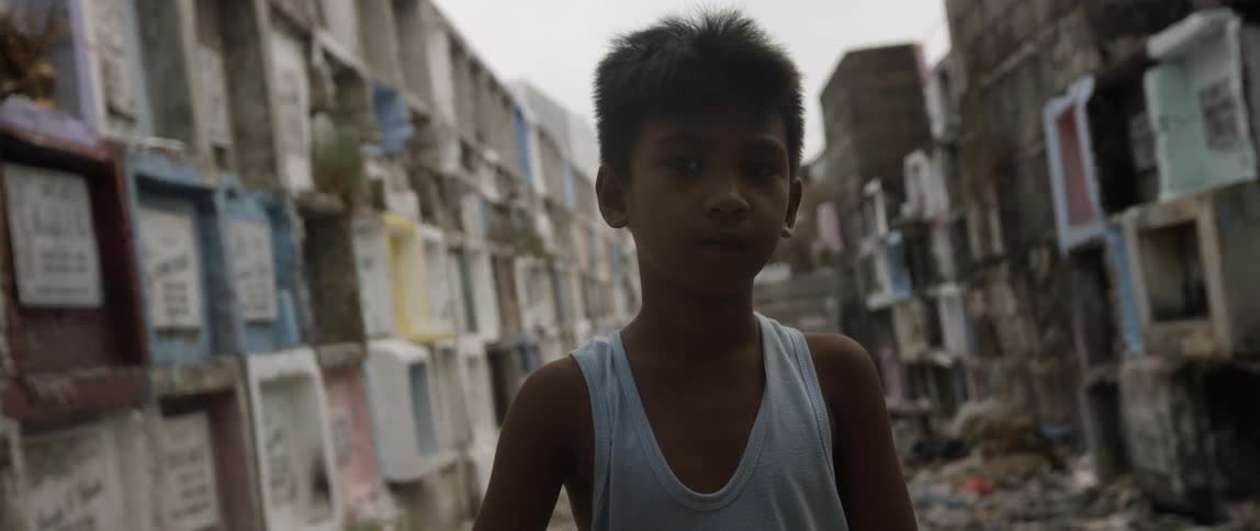 A child looks into the camera with containers surrounding him