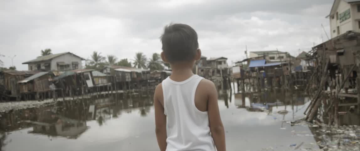 Little boy looking at what's left of his neighborhood after a hurricane