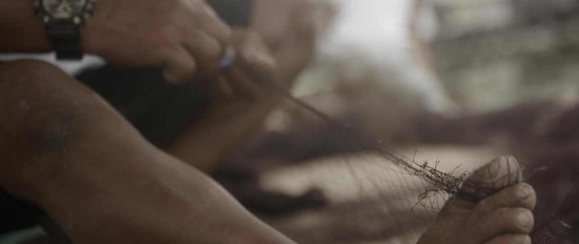A person is pulling string and tying it