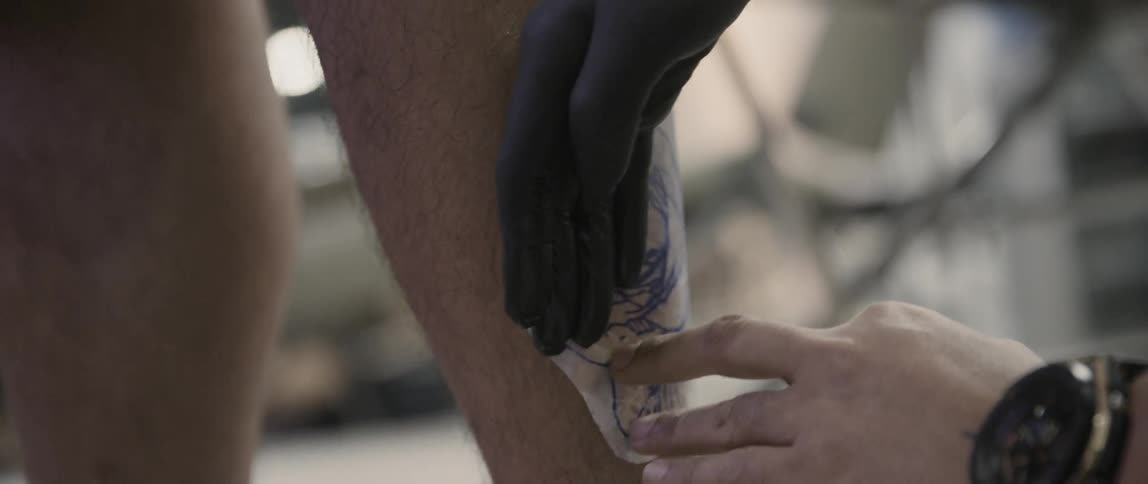 An artist gets ready to give a man a tattoo