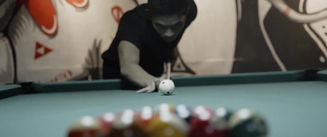 Man makes breaking shot in pool game