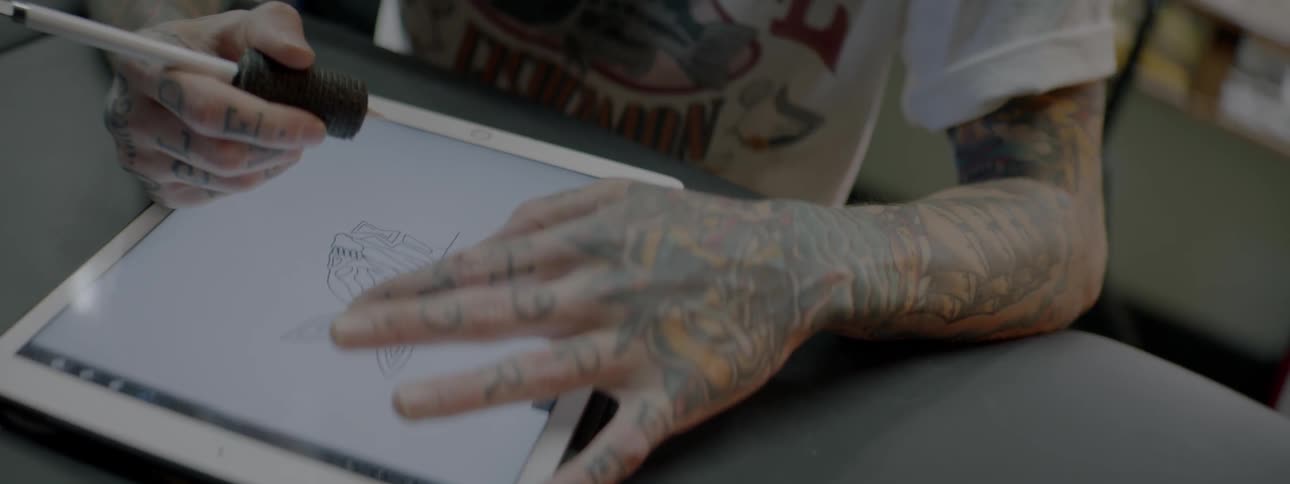 Tattoo artist tracing a rabbit design on a digital tracing board