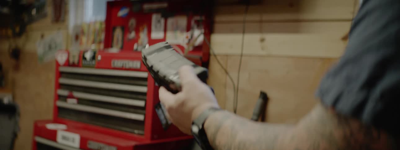 A person is holding tools in a workshop