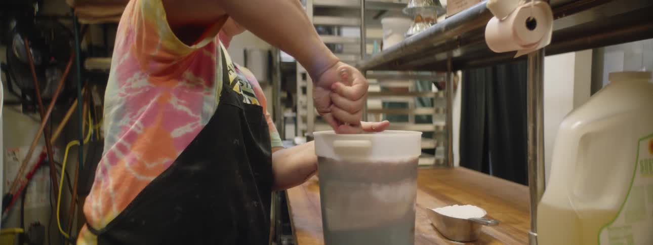 A woman mixing a bucket in a kitchen