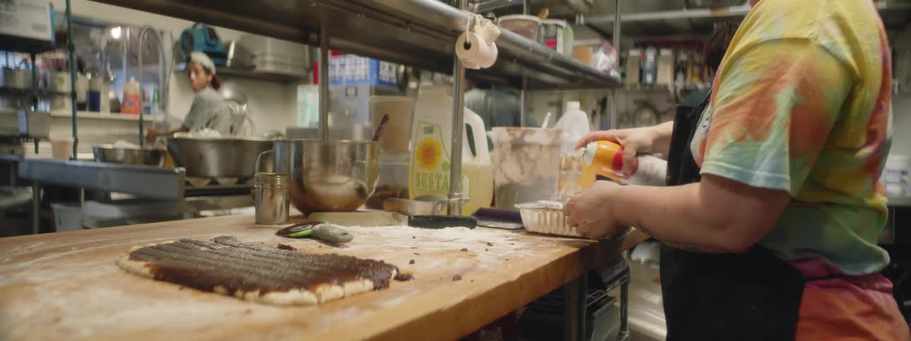 A person is preparing pastries in a restaurant kitchen