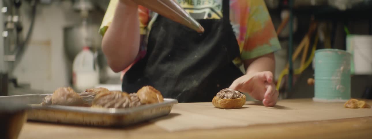 A baker squeezing icing on a pastry