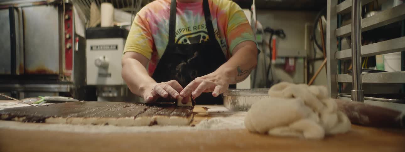 A person is preparing pastries in a kitchen