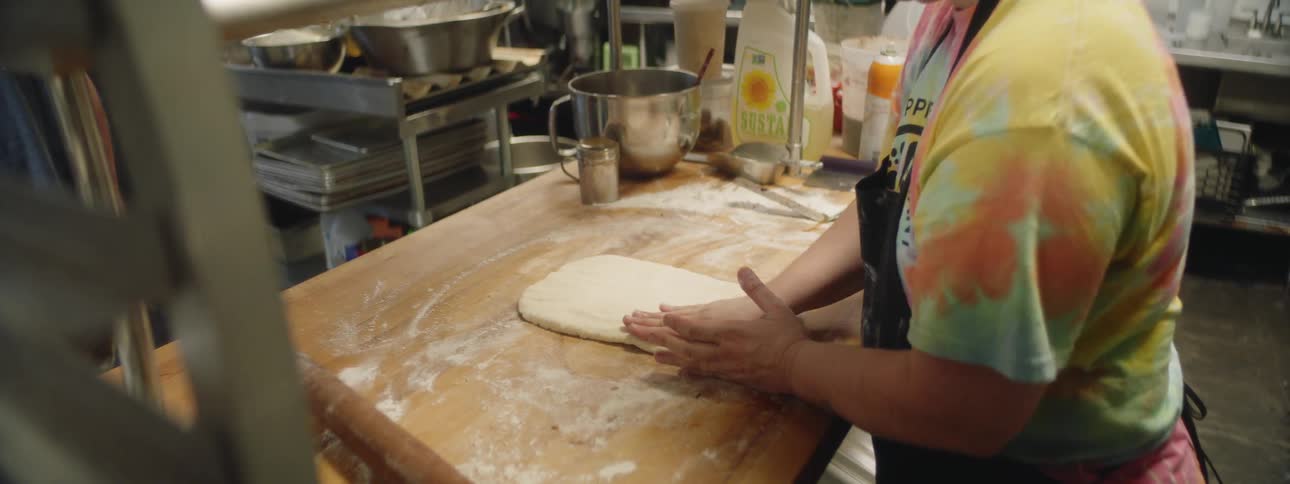A chef making some dough in a kitchen