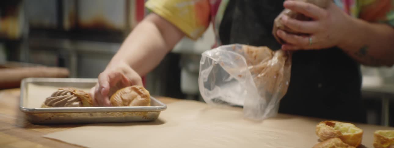 A woman puts baking on a tray