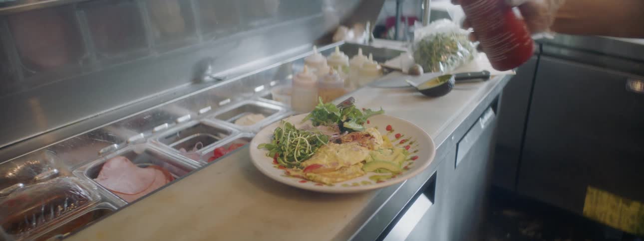 A chef puts a sauce around the edge of a plate