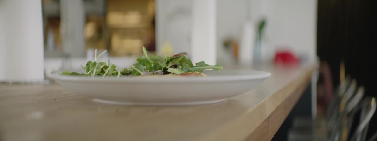 Omelette on plate with greens on counter