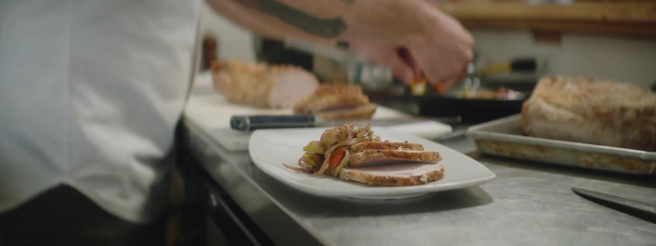 A restaurant worker is preparing a dish in the kitchen
