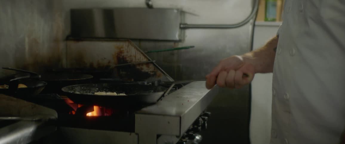 A man cooks at a stove