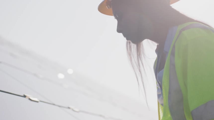 A female construction worker touching a structure