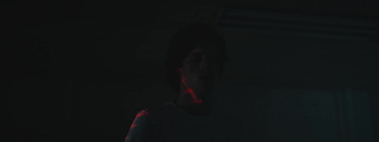 Teenage boy in dark room with strobe light and red reflection