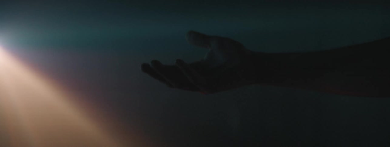 A person is reaching their hand in front of a strobe light
