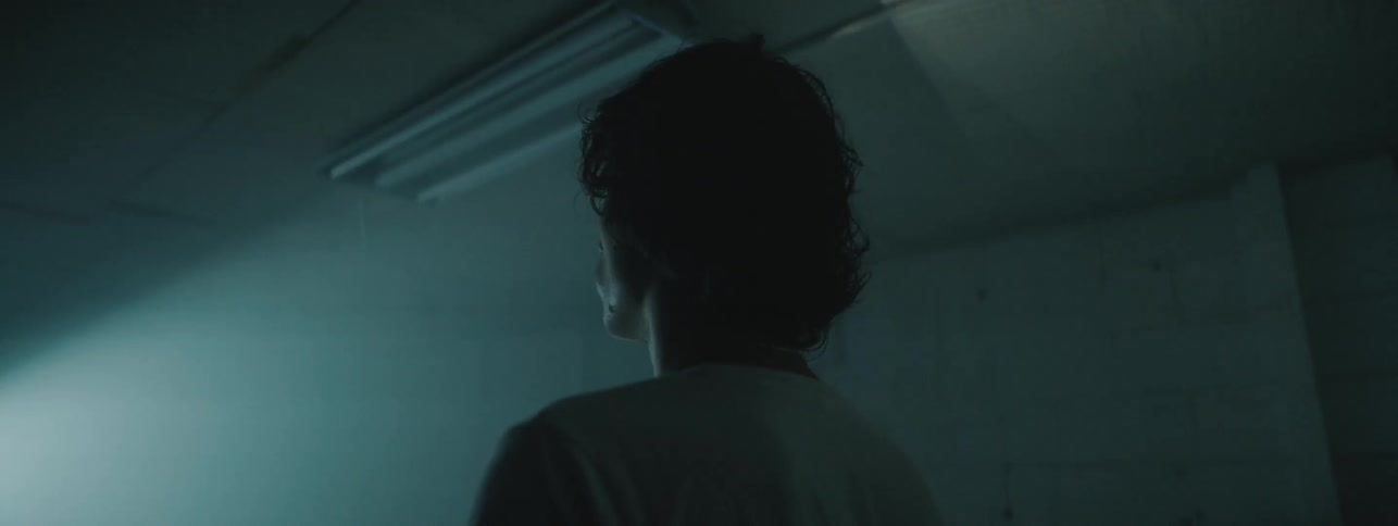 Lights flash on a man in a dark room