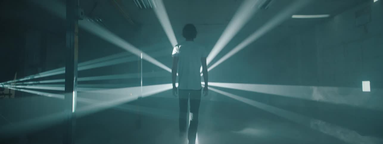 A man walking into a light show