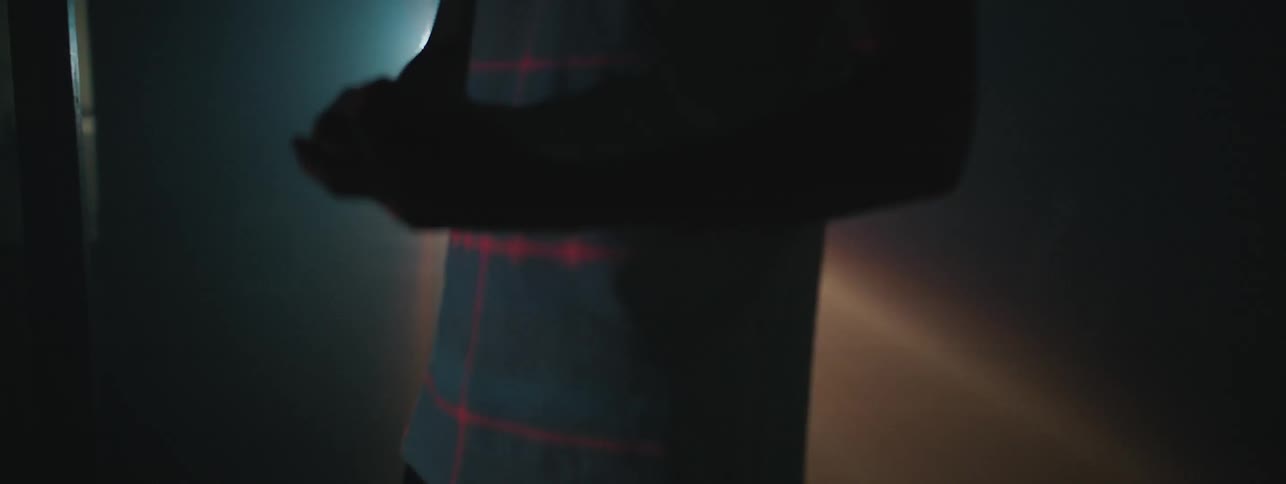 A young boy stands in a room with a flashing light