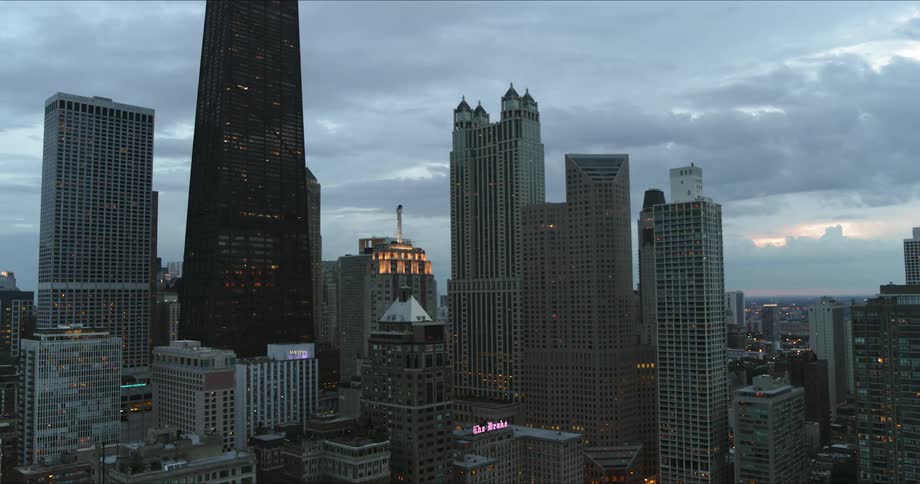 An aerial view of skyscrapers in a large city at dusk