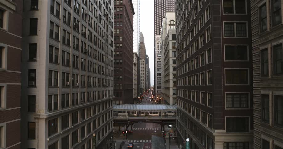 A street surrounded by skyscrapers in a city during the day