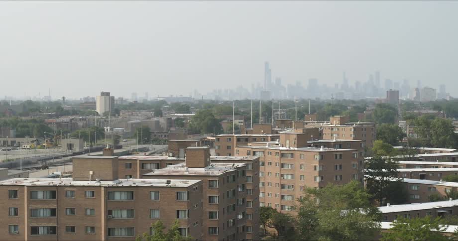 An aerial view of apartment buildings with a skyline in the distance