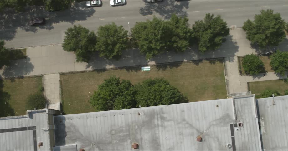 The camera flies over a road and buildings