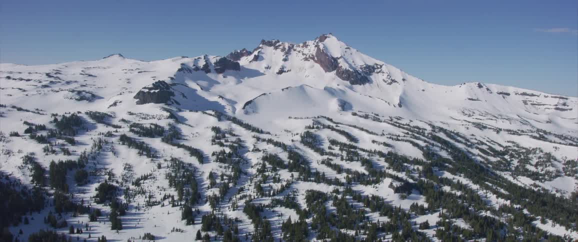 A mountain covered with snow with the sky in the background