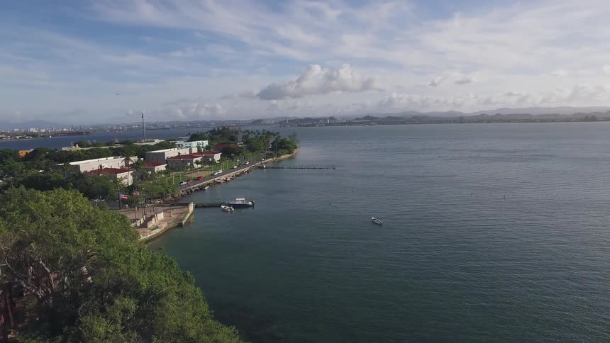 A coastal town has boats docked and a large square by the water