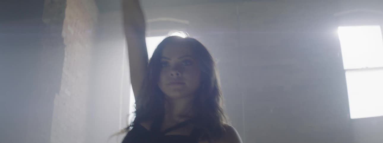 A woman dances in bright backlight