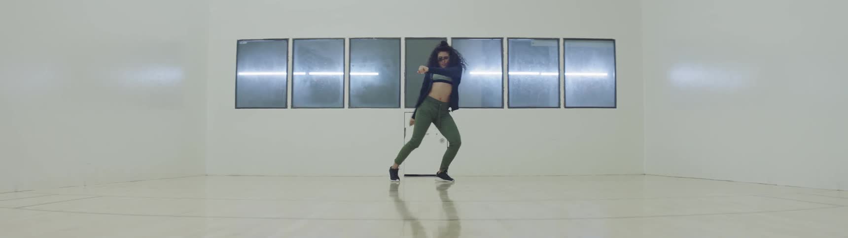 A female dancer dancing in front of windows