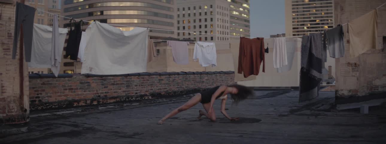 A woman on a rooftop practicing her dancing