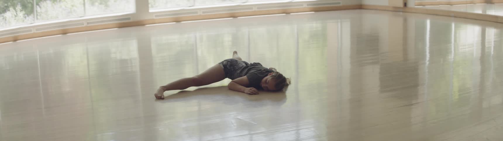 Dancer practices dance routine in empty studio