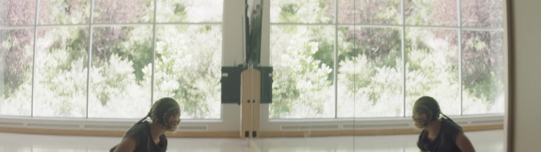 A woman dances enthusiastically in front of a mirror