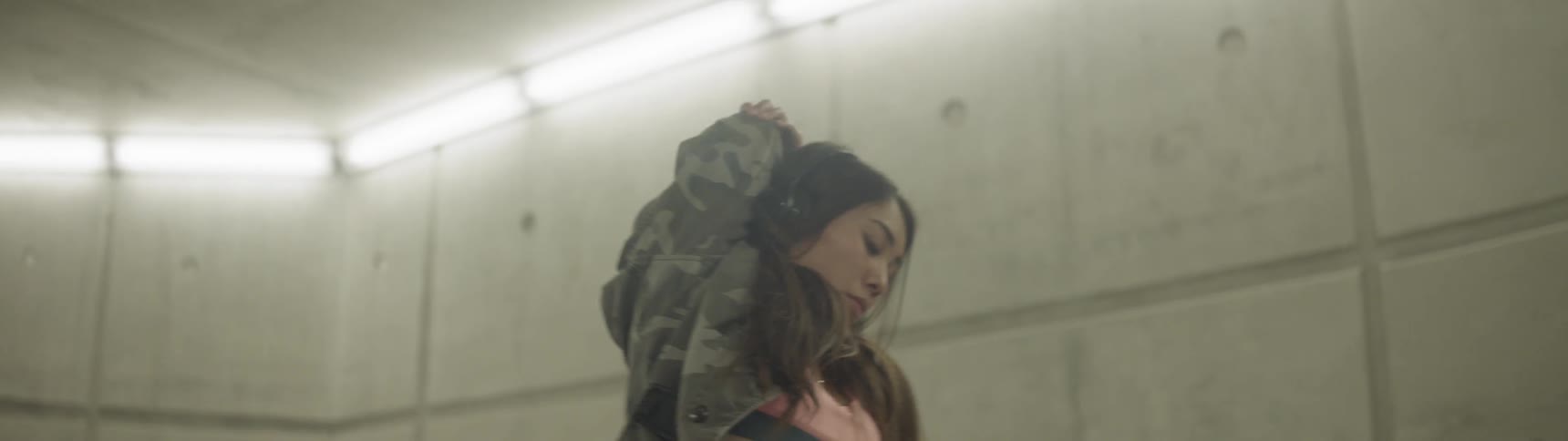 A woman is stretching wearing headphones
