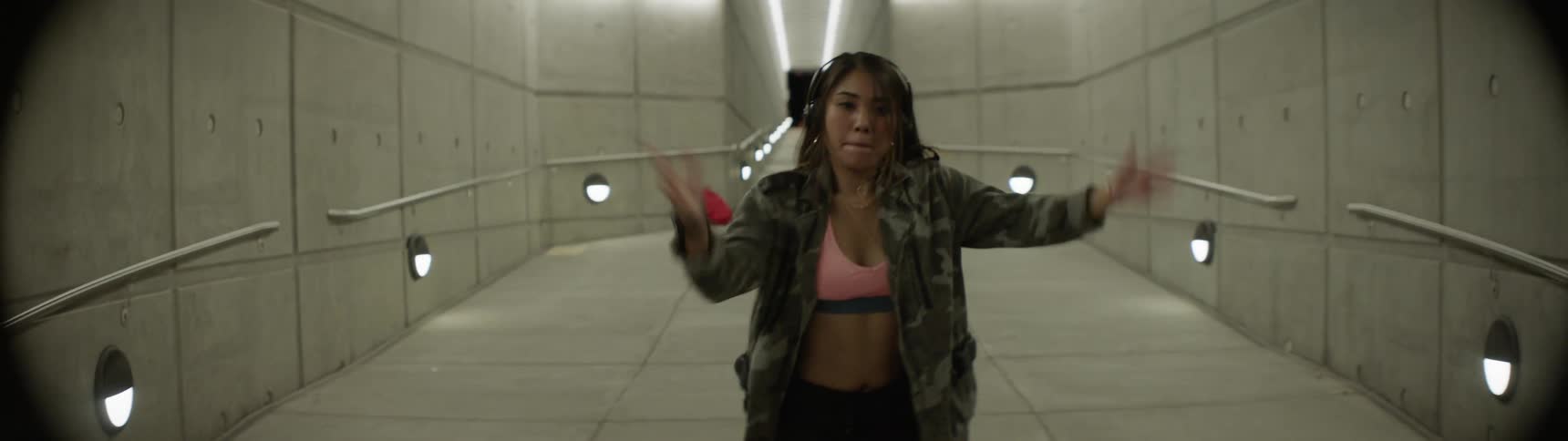 A young woman dances in a tunnel