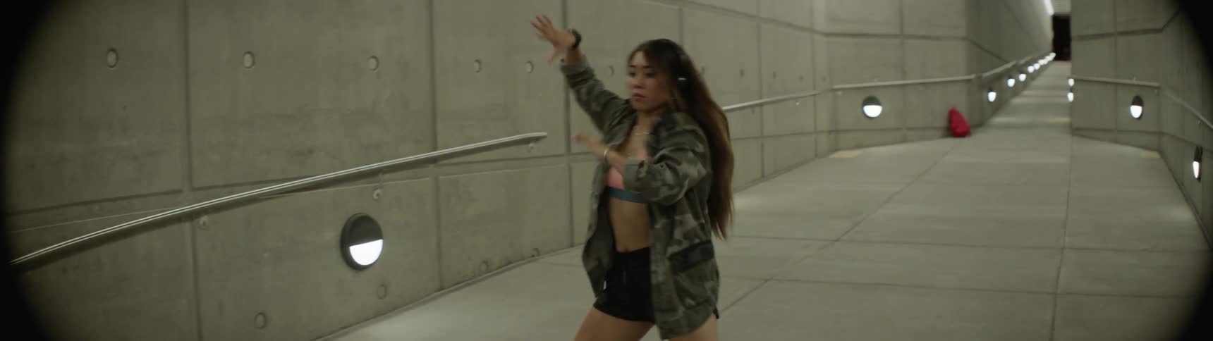 A woman dancing in a tunnel