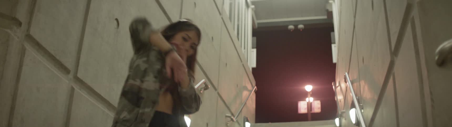 A woman dances in a stairwell
