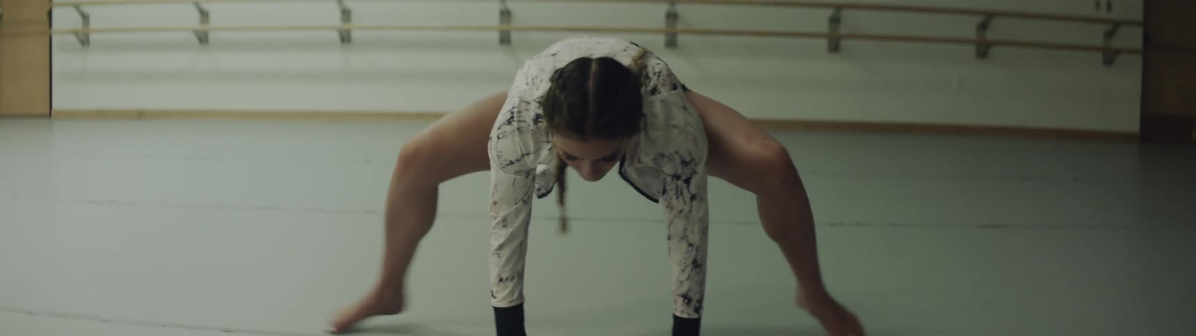 A woman is doing stretched indoors