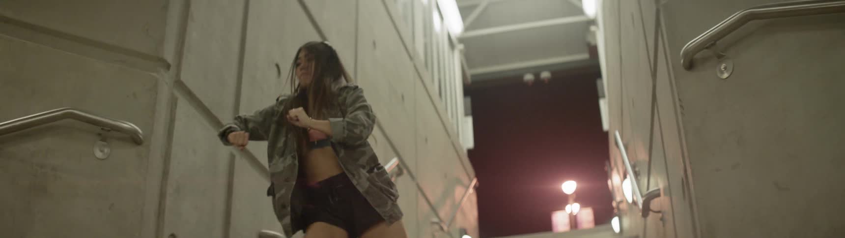 Woman dancing on stairs at night