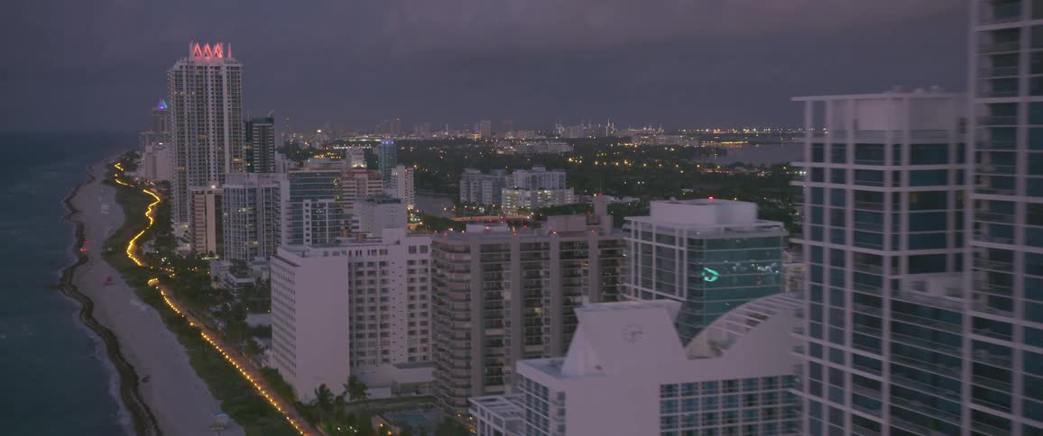 A city surrounded by a large body of water at dusk