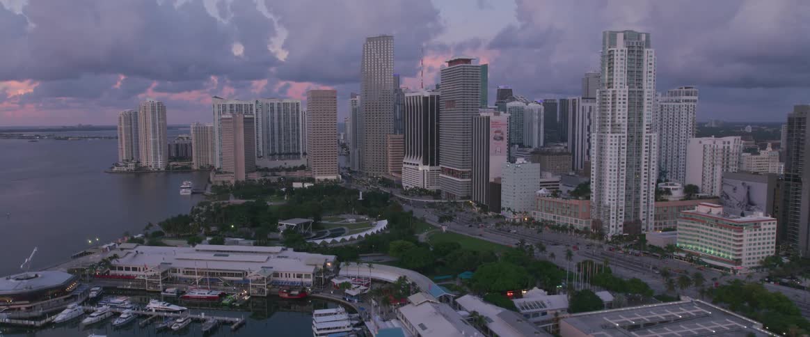 The sun is setting behind the city near the shore