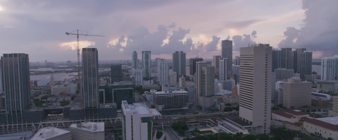 An aerial view of a cityscape that is surrounded by the sky and water
