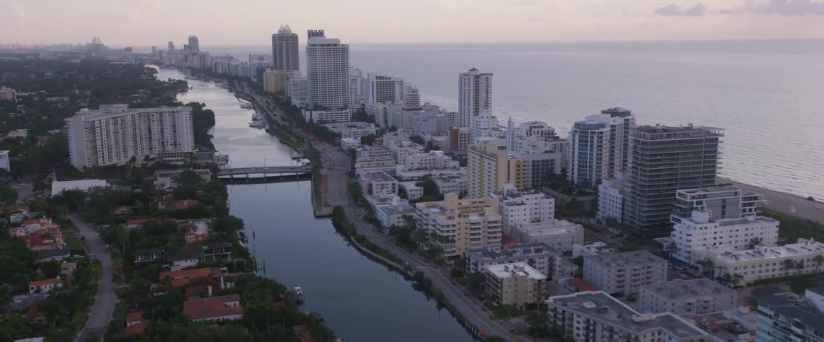 Tall buildings bordered by beach and river