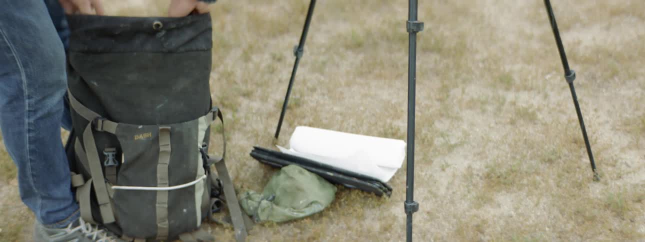 A male artist setting up an easel and palette for painting