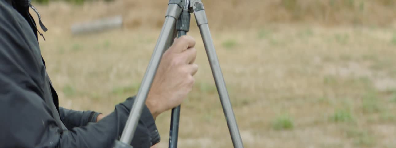 A man sets up a tripod