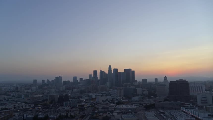 Sunset on the horizon behind downtown skyscrapers